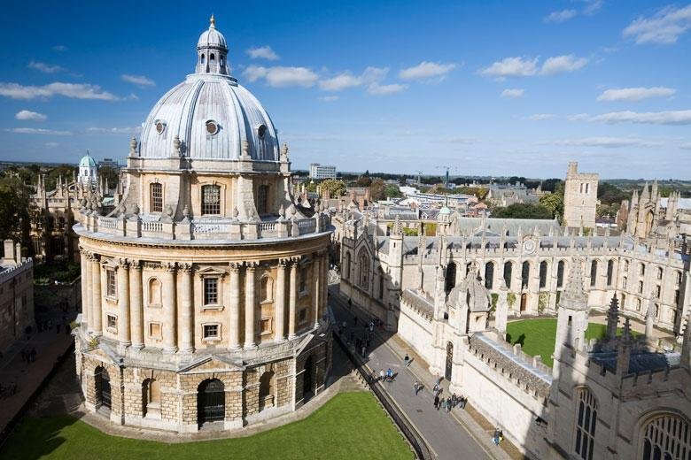 International students walking in a historic UK university campus with classic Oxford-style architecture